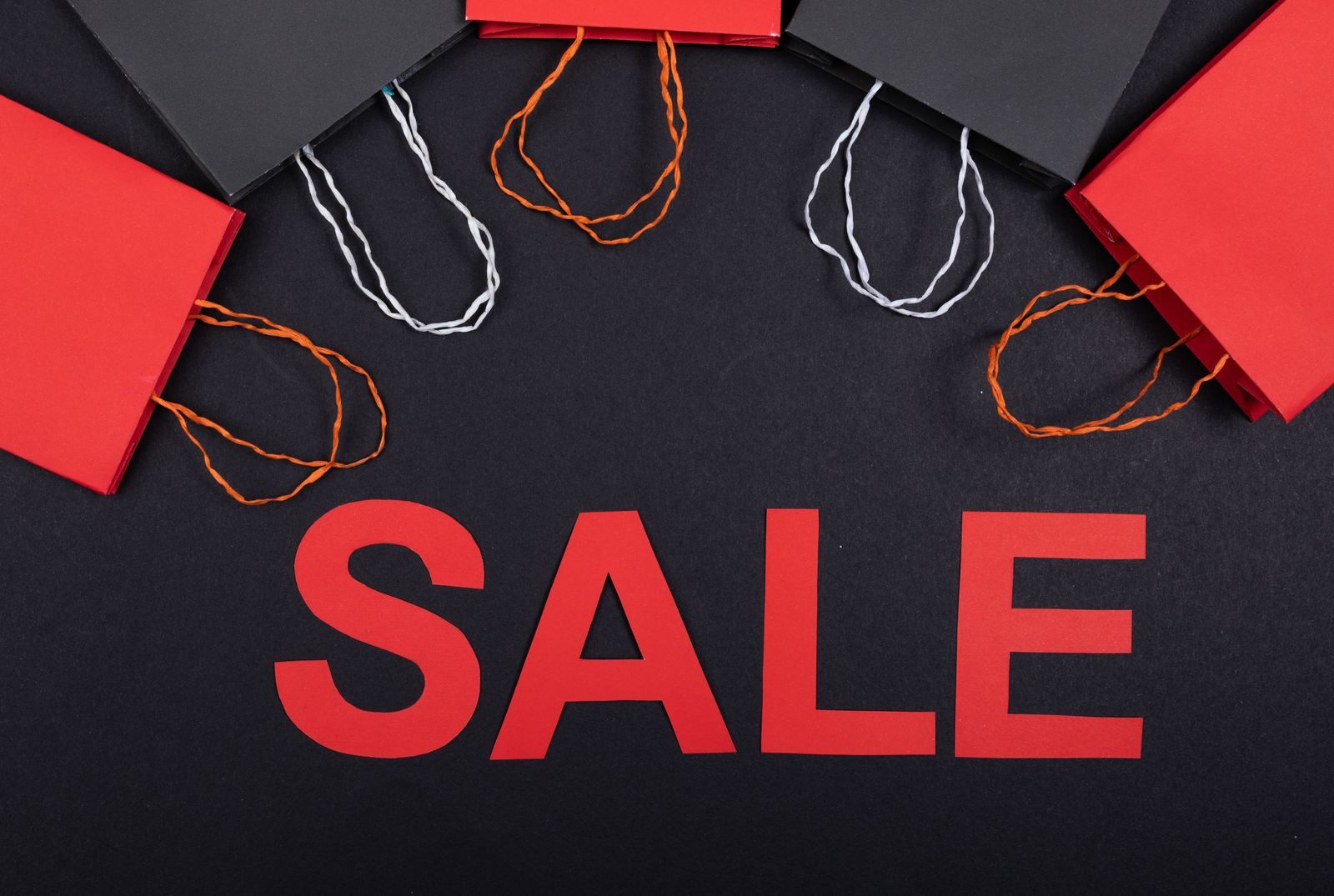 Red and black shopping bags printed with the word sale, the mood of Black Friday cruise deals 2026