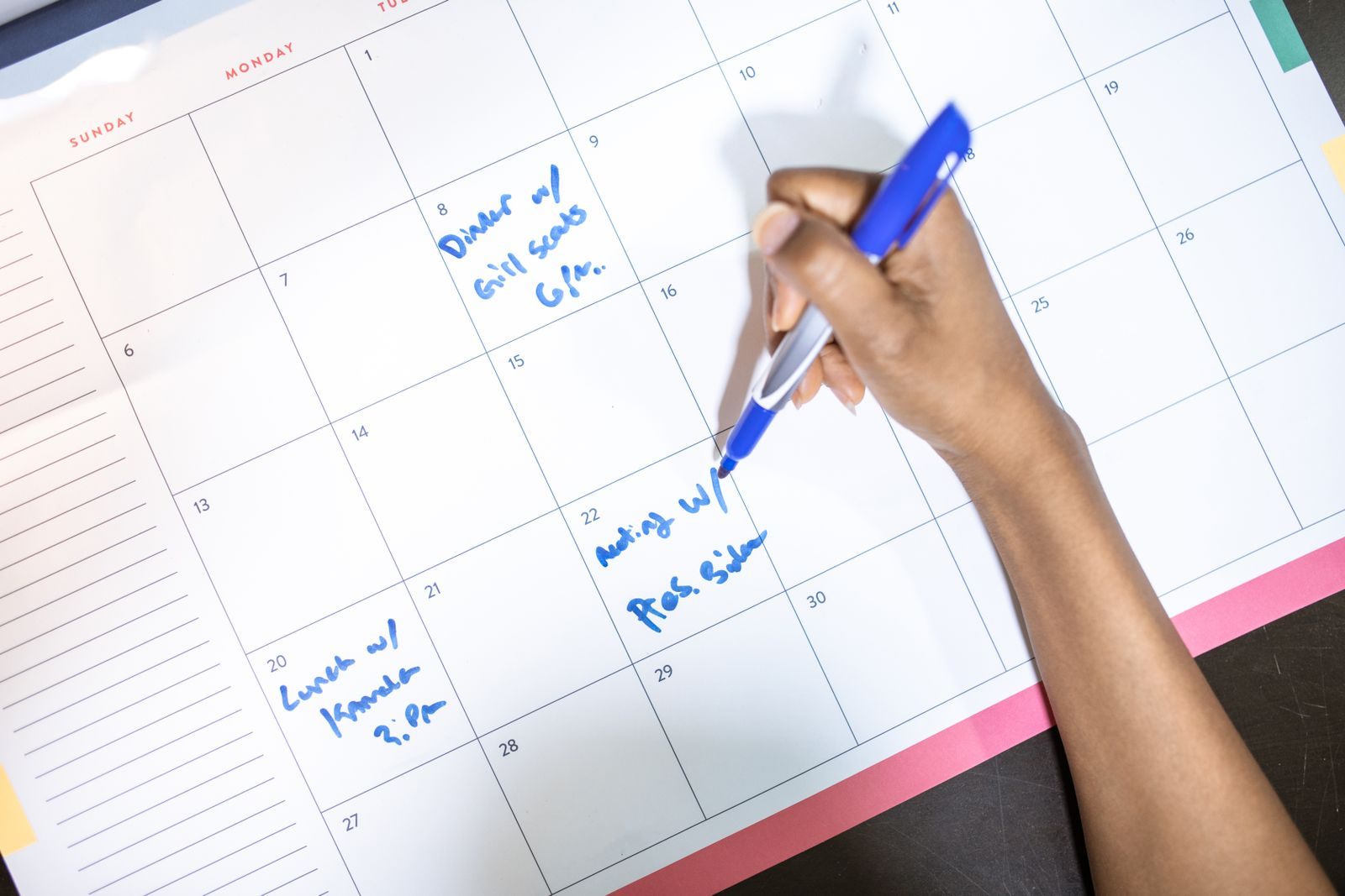 A hand writing dates in a calendar, planning around cruise sales 2027